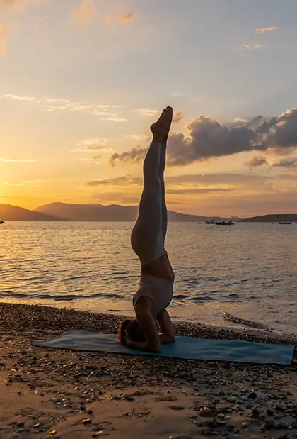 Woman doing yoga on Tolo beach during golden hour